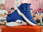 Pair of blue Nike Hyperdunk high-top shoes with black Swooshes and white soles
