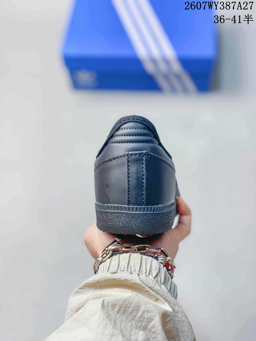 Rear view of the black sneaker showing the padded collar, heel panel and textured outsole edge.