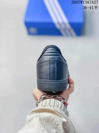 Rear view of the black sneaker showing the padded collar, heel panel and textured outsole edge.