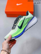 Side view of the sneaker showing the black Nike Swoosh, green upper panels, blue midsole accent, and textured heel.