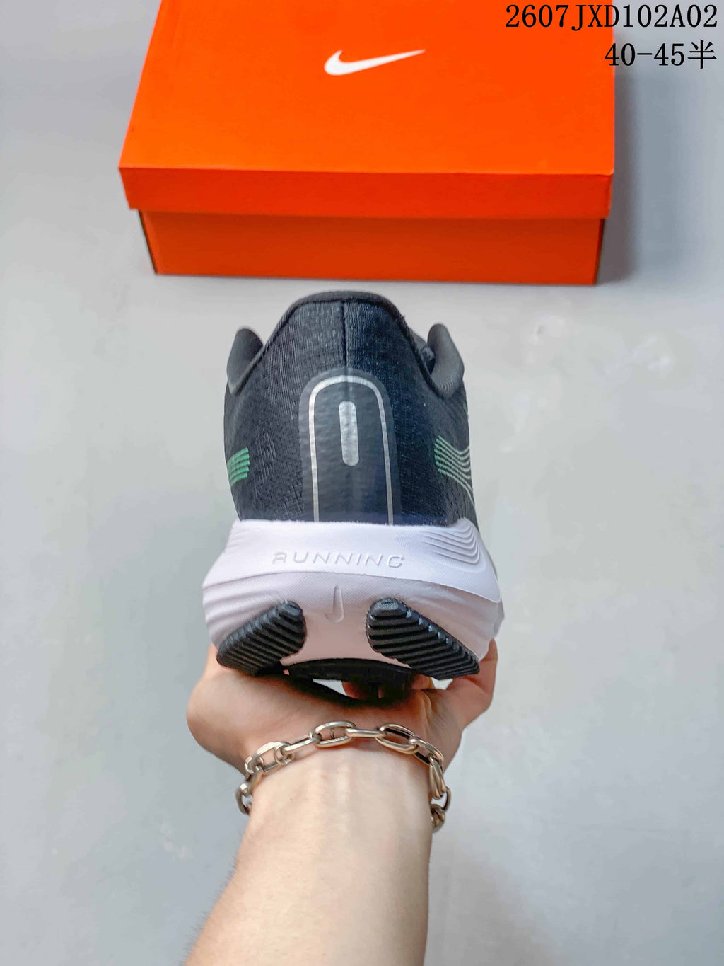 Rear view of a charcoal Nike running shoe with a white heel midsole and black outsole; image text shows 40–45.