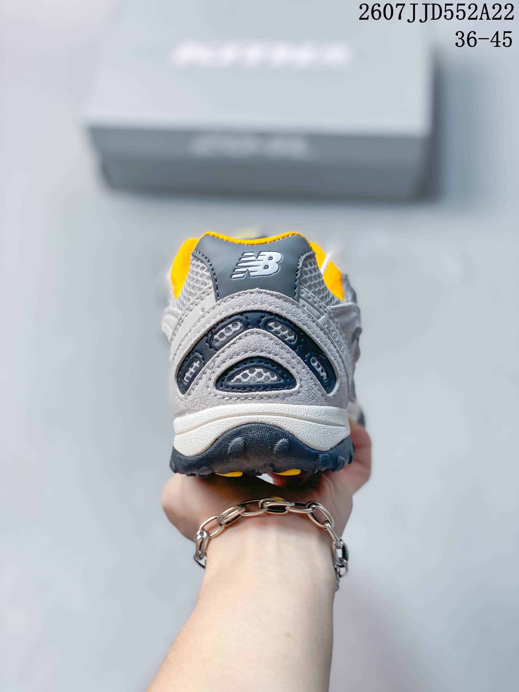Rear view showing the layered heel structure, mesh panels, and yellow collar lining.