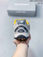 Rear view showing the layered heel structure, mesh panels, and yellow collar lining.