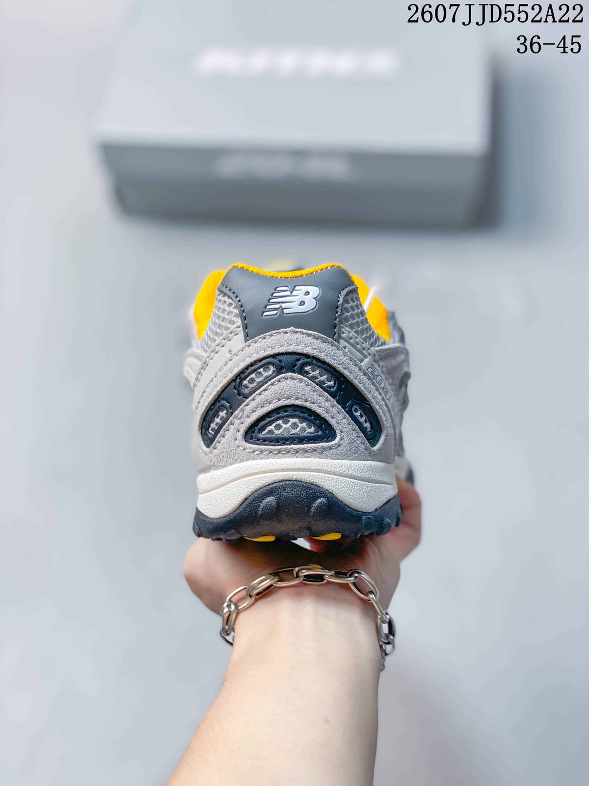 Rear view showing the layered heel structure, mesh panels, and yellow collar lining.