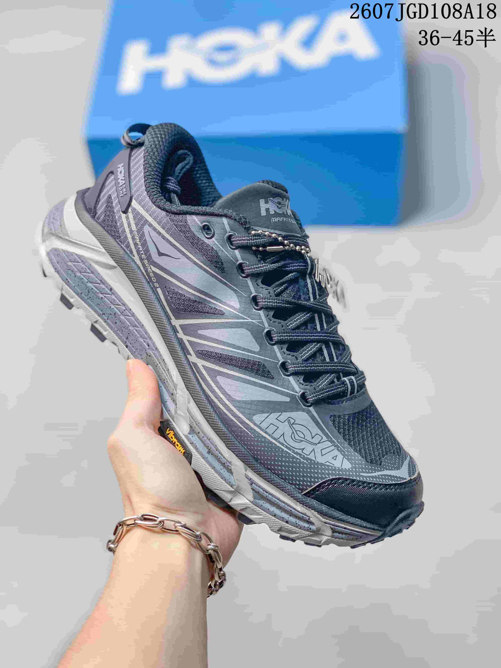 Dark gray and purple HOKA Mafate Speed 2 sneaker with layered side panels and a light outsole.