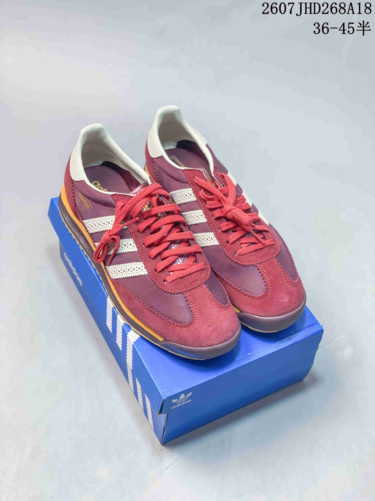 Pair of burgundy adidas SL 72 sneakers displayed on a blue adidas shoebox, with the style code and size range visible above.