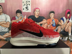 Side view of a red and white Nike basketball sneaker with a black logo
