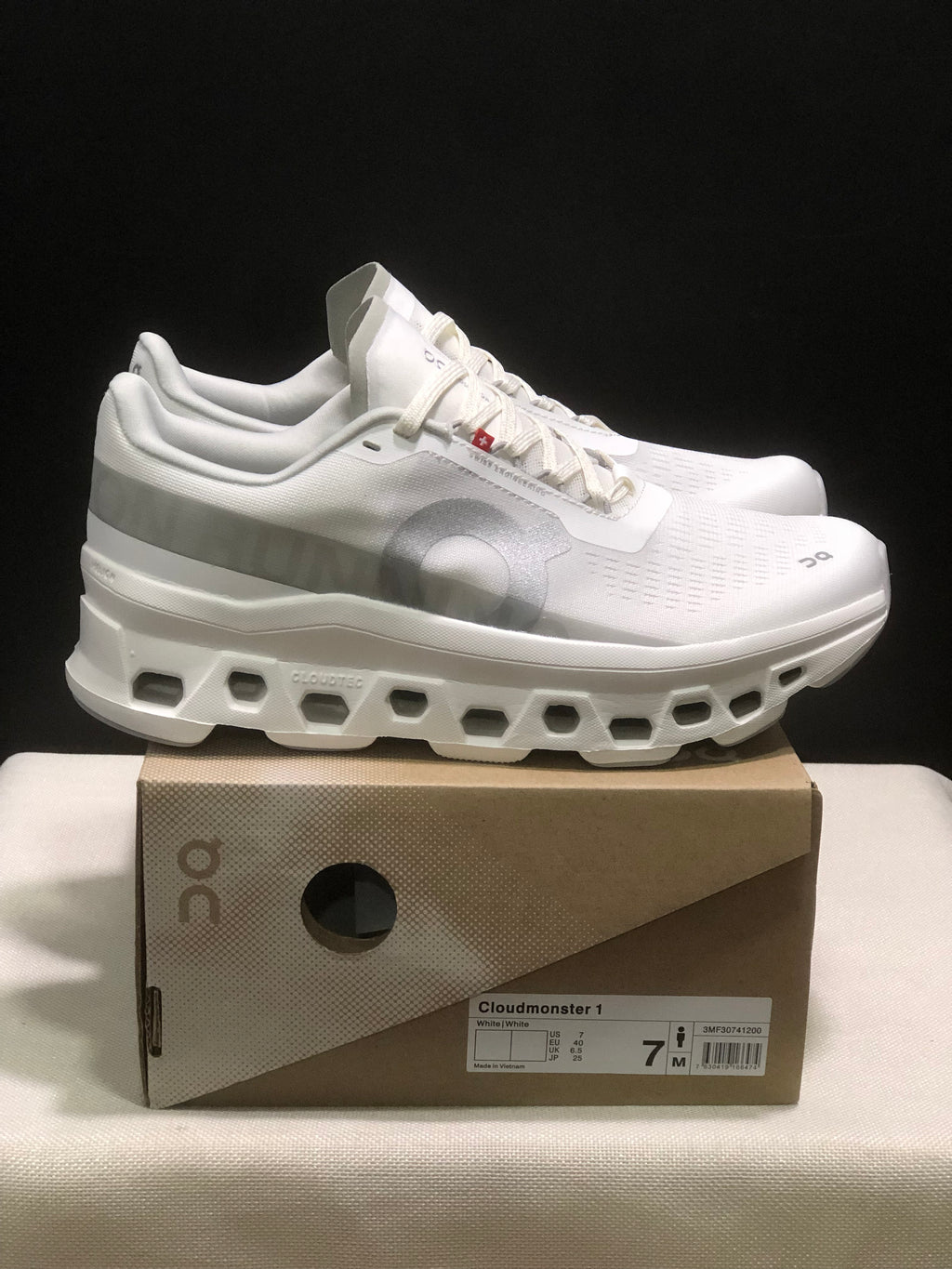 Side view of the white On Cloudmonster 1 sneakers and shoe box.
