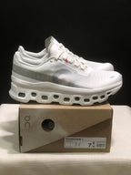 Side view of the white On Cloudmonster 1 sneakers and shoe box.