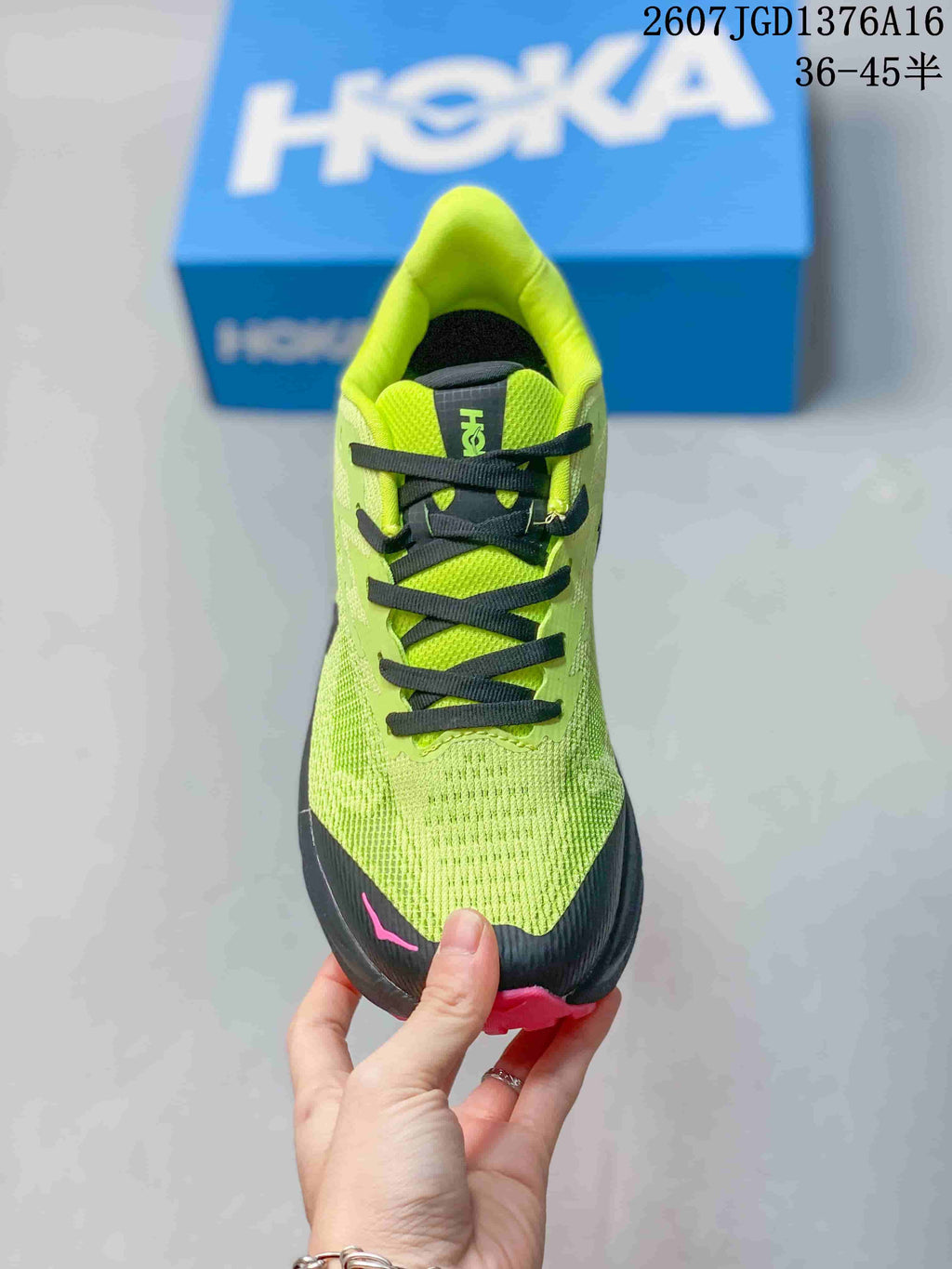 Top view of the green running shoe showing black laces, black toe protection, and pink detailing.