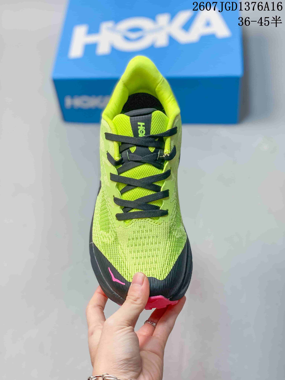Top view of the green running shoe showing black laces, black toe protection, and pink detailing.