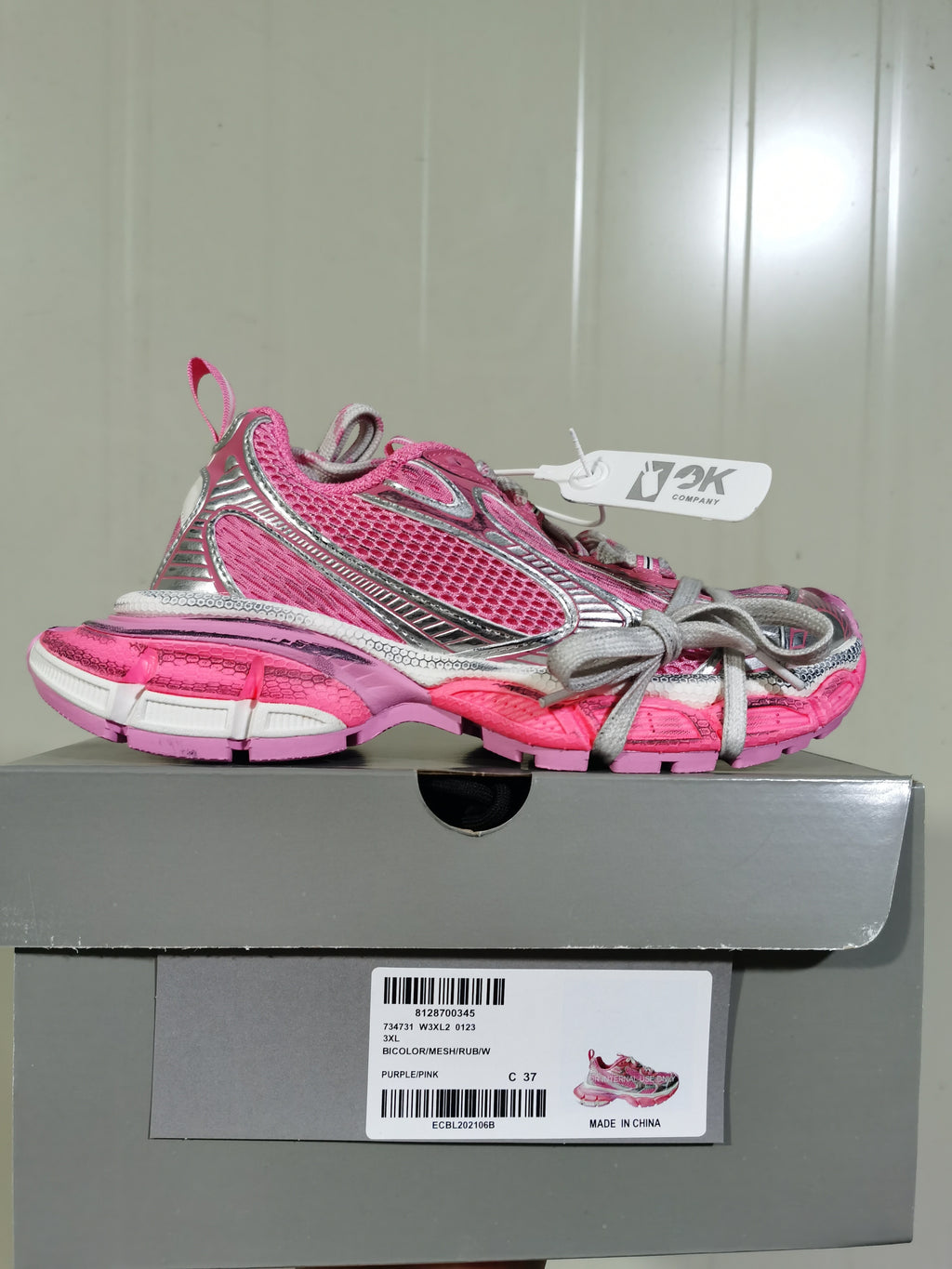 Side profile of the sneaker displayed on its box; the label shows style code 0123, color text “PURPLE/PINK,” and size marking “C 37.”