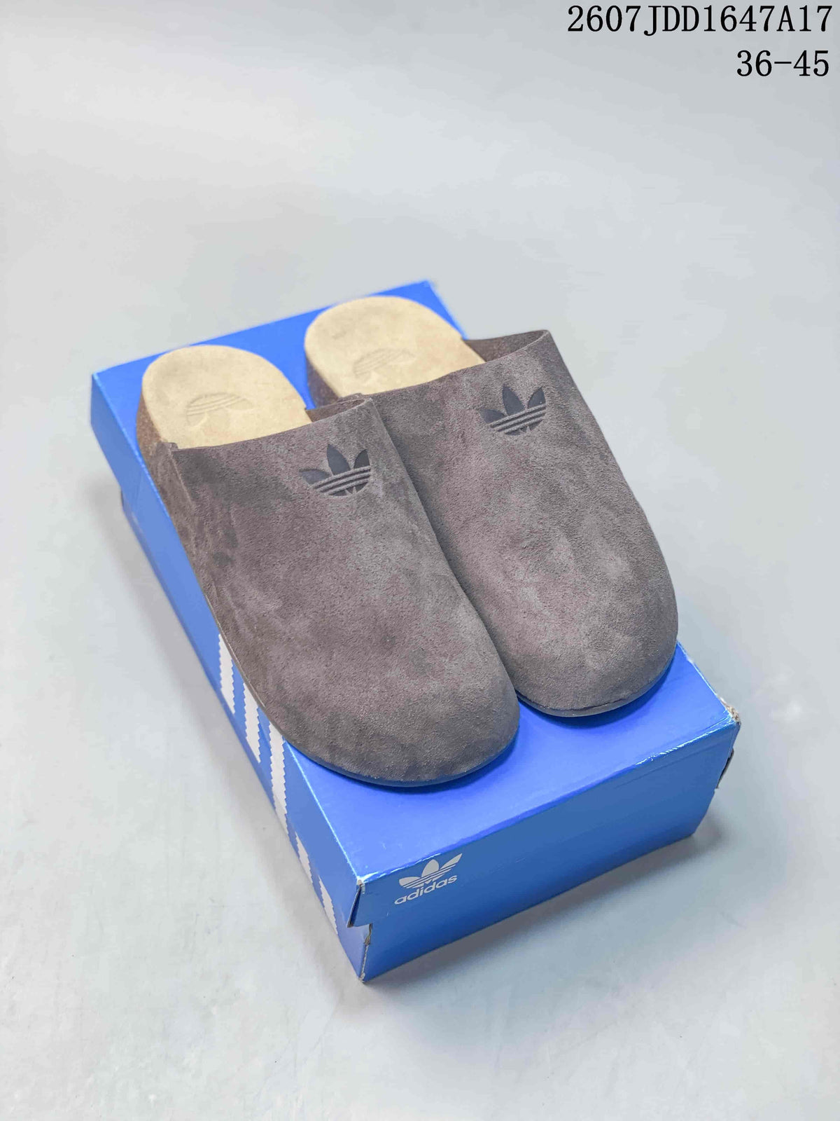 Brown adidas Adimule mule slides displayed on a blue shoebox.