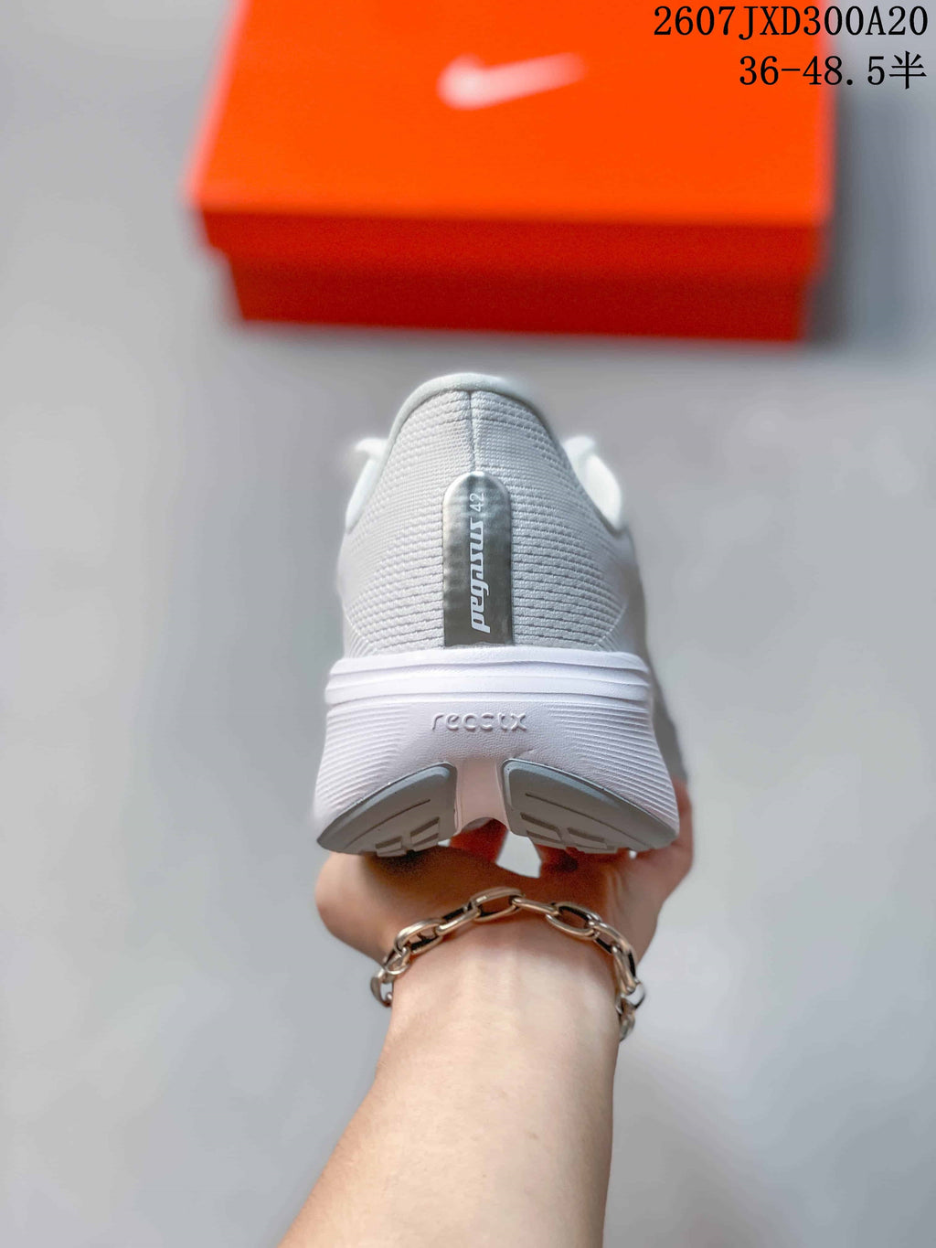 Rear view of the white sneaker showing the Pegasus 42 heel label, layered heel construction, and gray outsole sections.