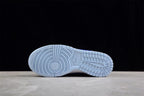 Underside view showing the light blue rubber outsole and its segmented tread pattern.