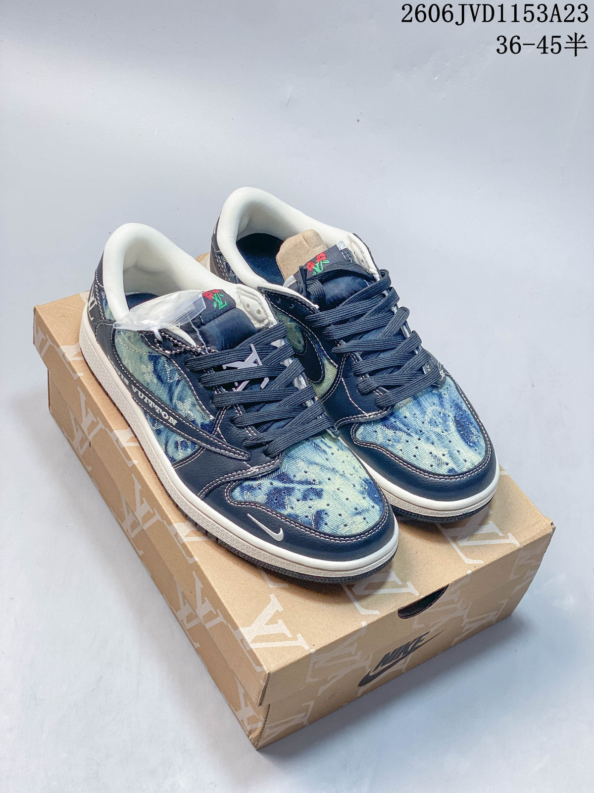 Pair of blue patterned low-top sneakers with navy laces shown on a branded box.