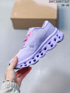 Side profile of a lavender On sneaker showing the textured upper, side logo, pink lace supports, and open segmented midsole; image text shows 2607JGD977A27 and 36–40.