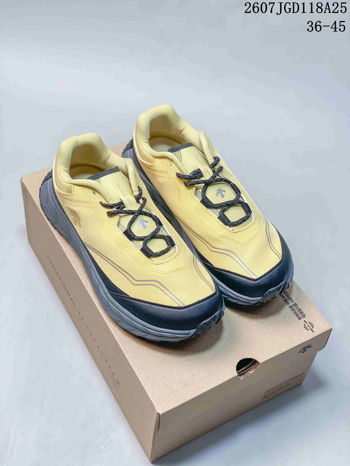 Pair of yellow and black DESCENTE low-top hiking sneakers displayed on a shoebox.