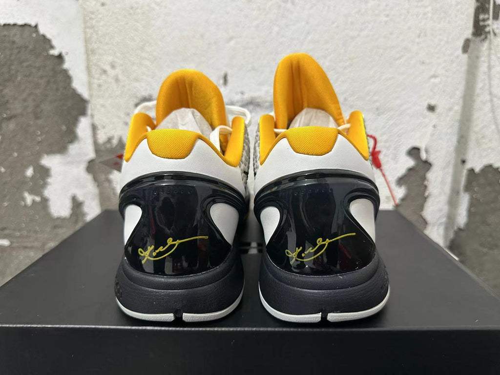 Rear view of white, yellow, and black Nike Kobe basketball shoes