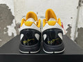 Rear view of white, yellow, and black Nike Kobe basketball shoes