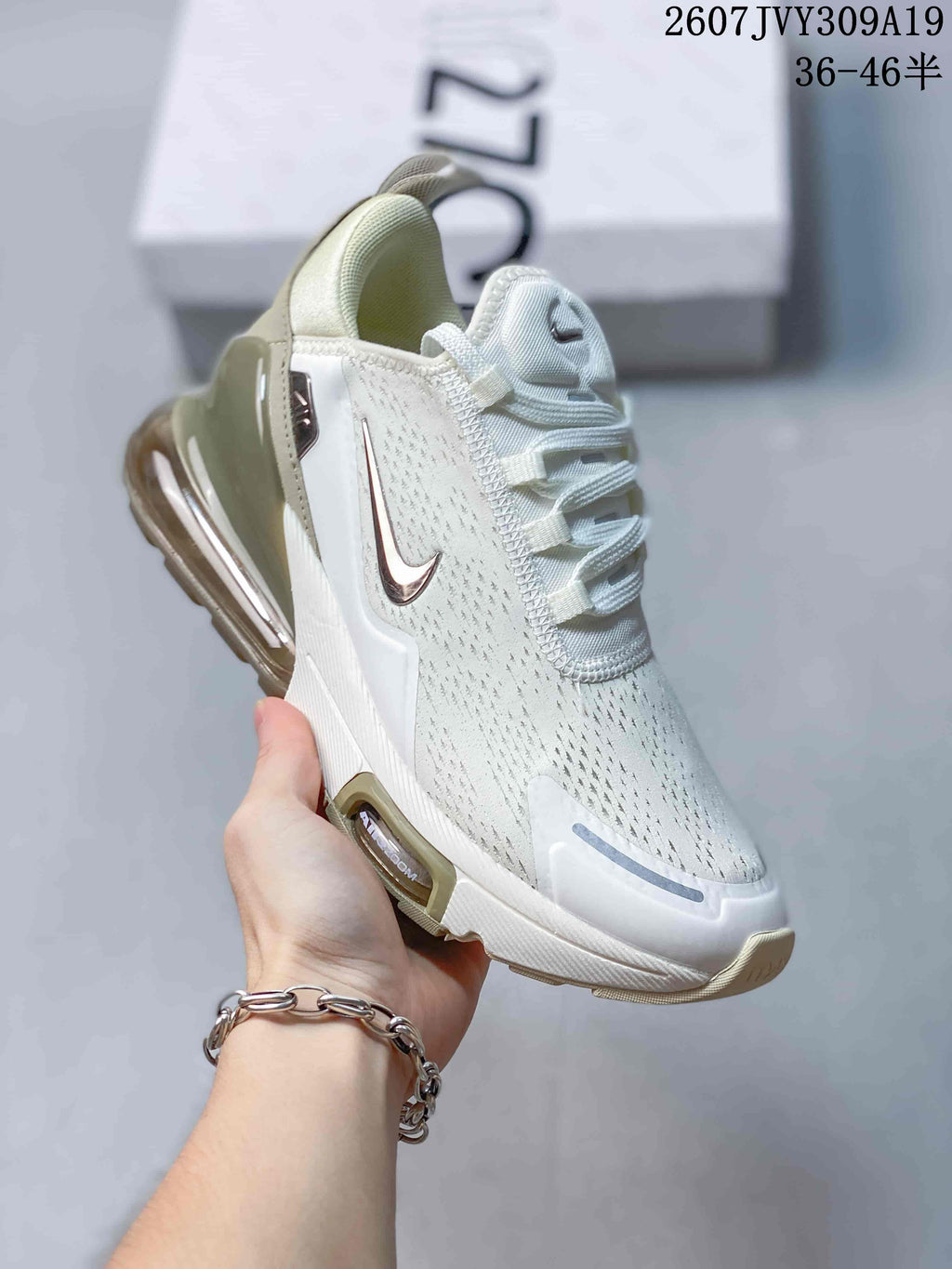 Angled side view of a white and light cream Nike Air Max 270 sneaker showing the side Swoosh and visible heel air unit.