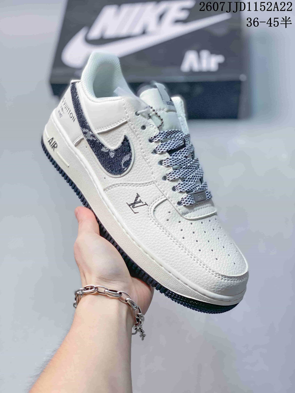 Angled side view of the white low-top sneaker showing the dark patterned side panel, perforated toe box, layered midsole, and outsole.