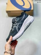 Side view of a navy and white ASICS sneaker showing layered side branding, textured upper, white midsole, and Guidance System marking.