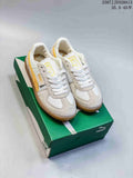 Pair of white and yellow PUMA Palermo Leather sneakers displayed on a green shoebox.