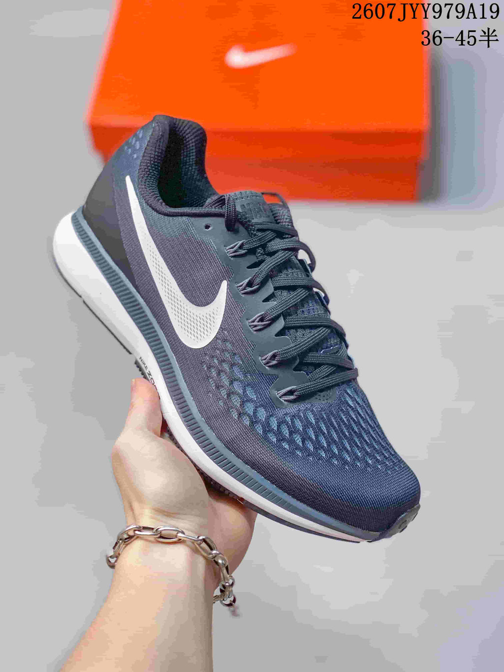Side view of a dark gray Nike running shoe showing the white Swoosh, lace system and white midsole.