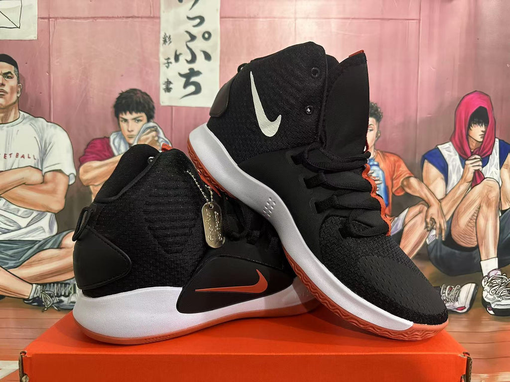 Pair of black high-top sneakers with orange details and contrasting white and gum-colored soles