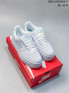 Pair of white and light blue Nike Court Vision Alta sneakers displayed on a red Nike shoe box.