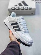 White adidas Entrap sneaker with black side stripes and a black outsole.