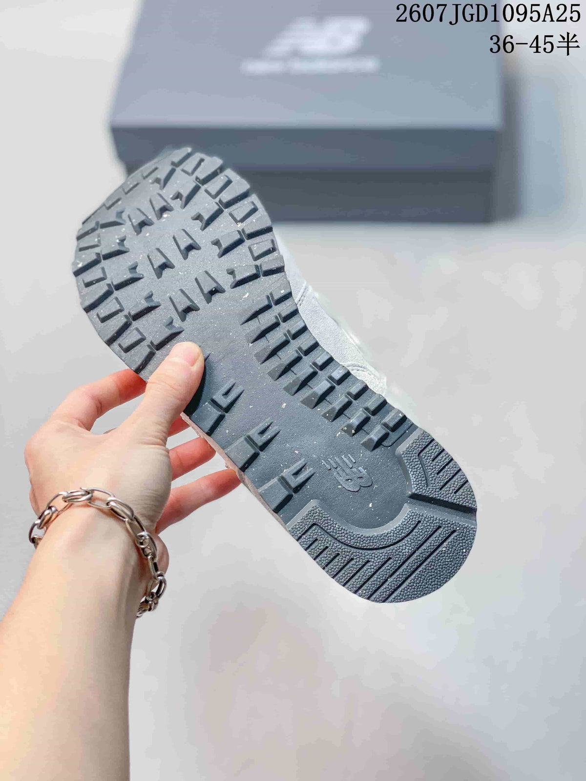 Close view of the textured dark rubber outsole on a New Balance 574 sneaker.