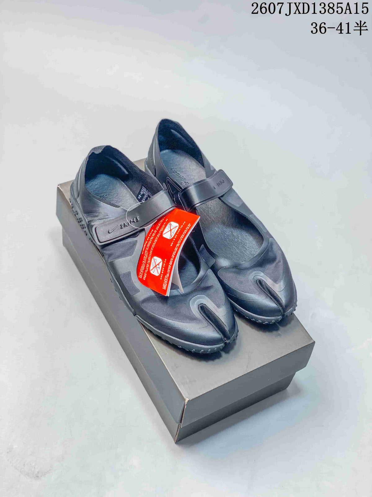 Pair of black Nike Air Rift split-toe shoes displayed on a shoebox, with an adjustable strap and red product tag visible.