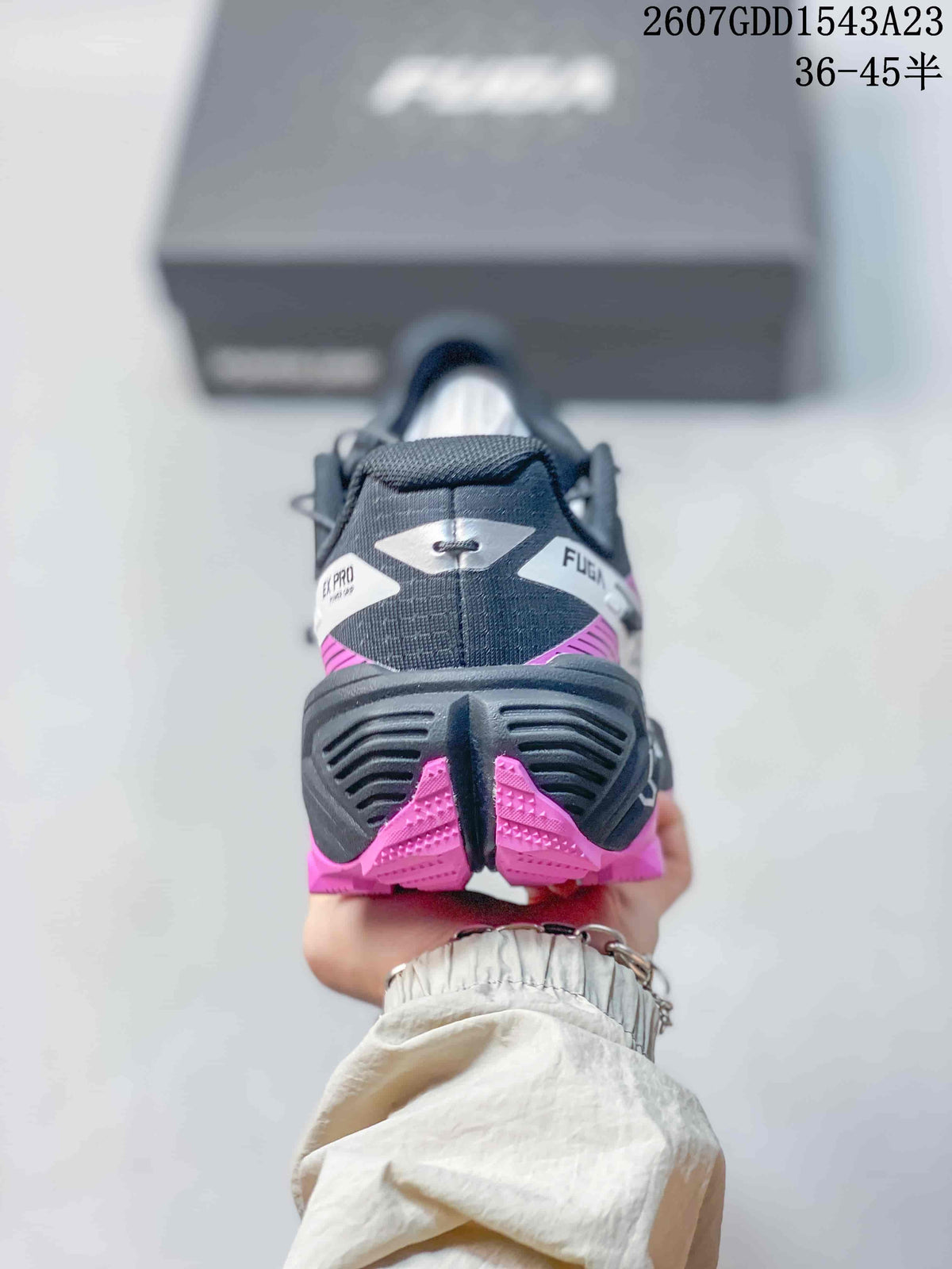 Rear view showing the black heel structure, pink outsole sections, and FUGA EX PRO branding.