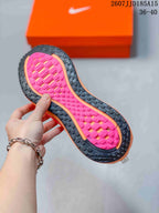 Underside view showing the black rubber outsole and bright pink patterned traction section.