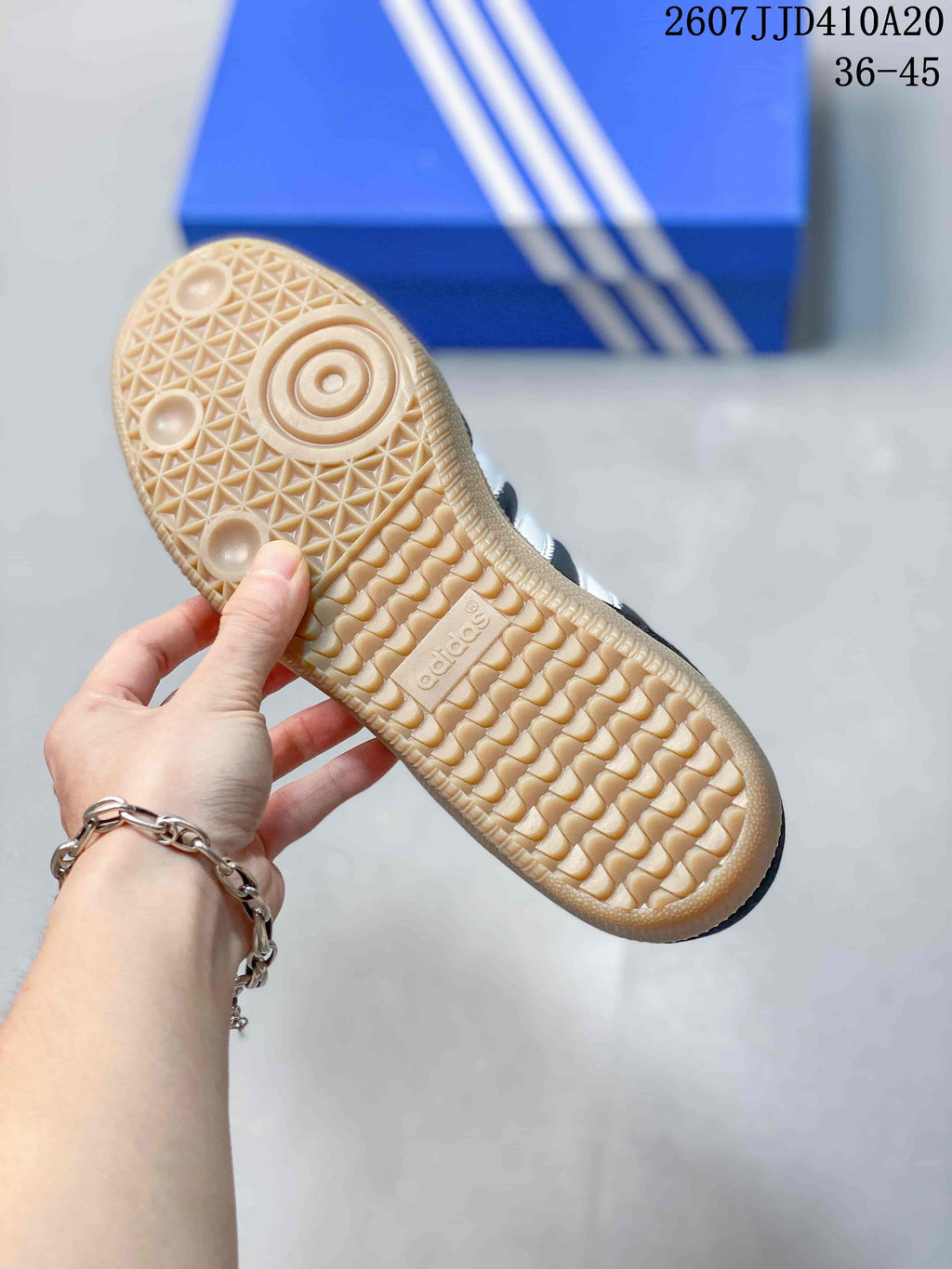 Close view of the textured gum-colored outsole with Adidas branding.