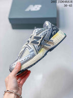 Side profile of a New Balance 1906A sneaker showing mesh panels, layered overlays, laces, and the segmented outsole.