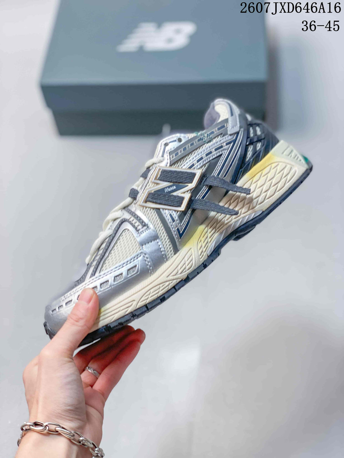 Side profile of a New Balance 1906A sneaker showing mesh panels, layered overlays, laces, and the segmented outsole.