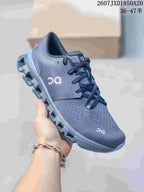 Side view of a dark gray On Cloud X 4 sneaker showing the knit-style upper, laces, and segmented outsole.