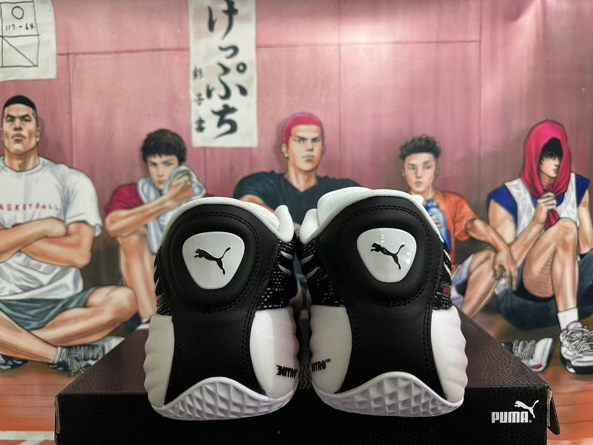 Rear view of black and white PUMA basketball shoes on a PUMA box