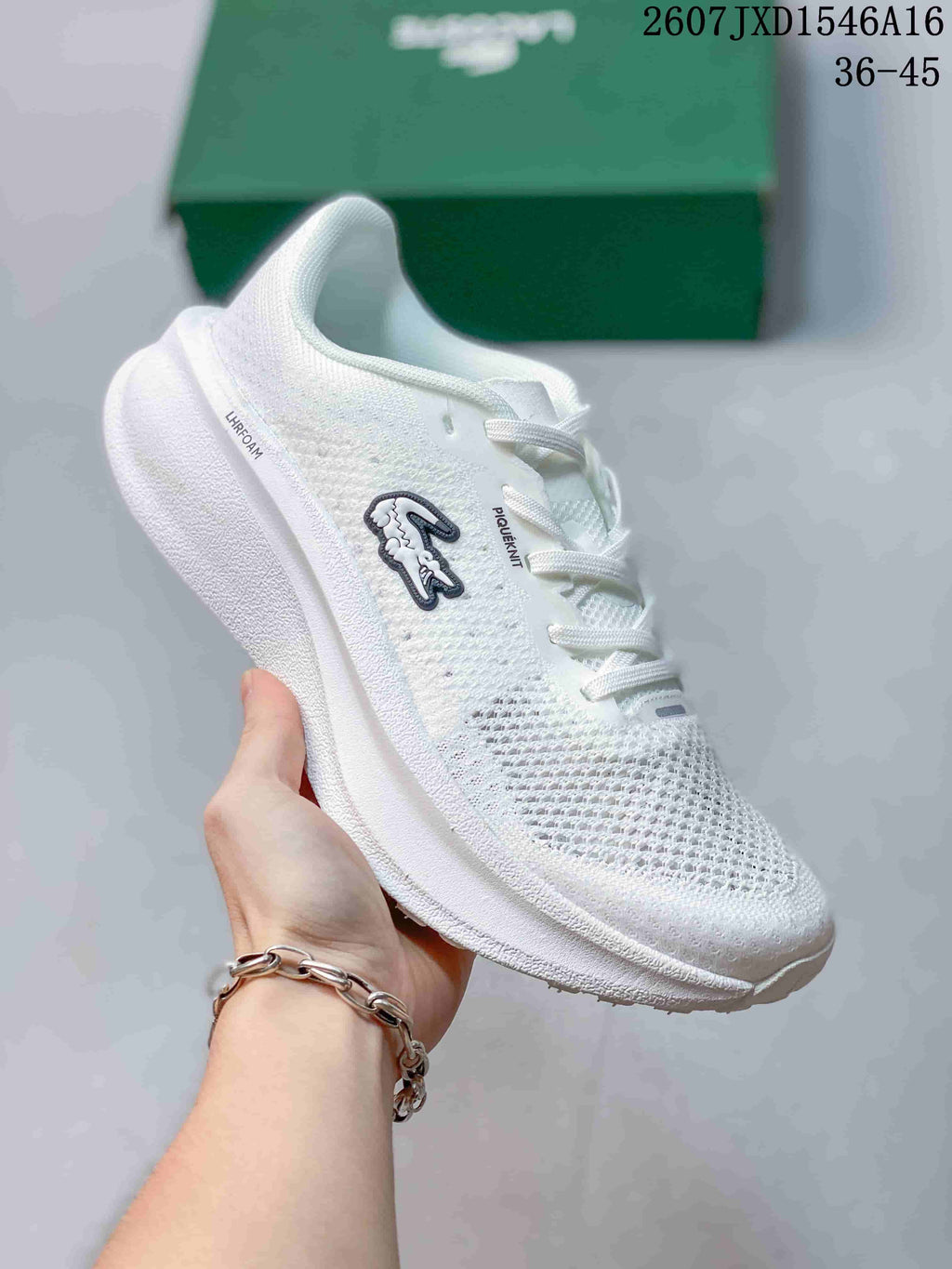 Angled side view of the white Lacoste sneaker showing the crocodile emblem, laces, textured upper, and raised sole.