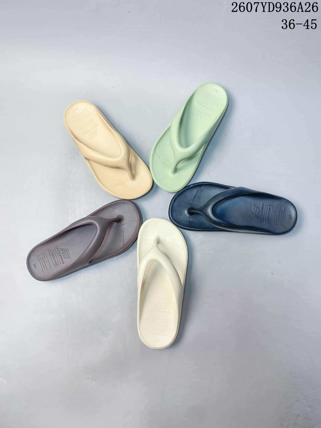 Five New Balance NB5601 flip-flop sandals arranged on a surface in cream, pale green, brown, navy and beige colorways.