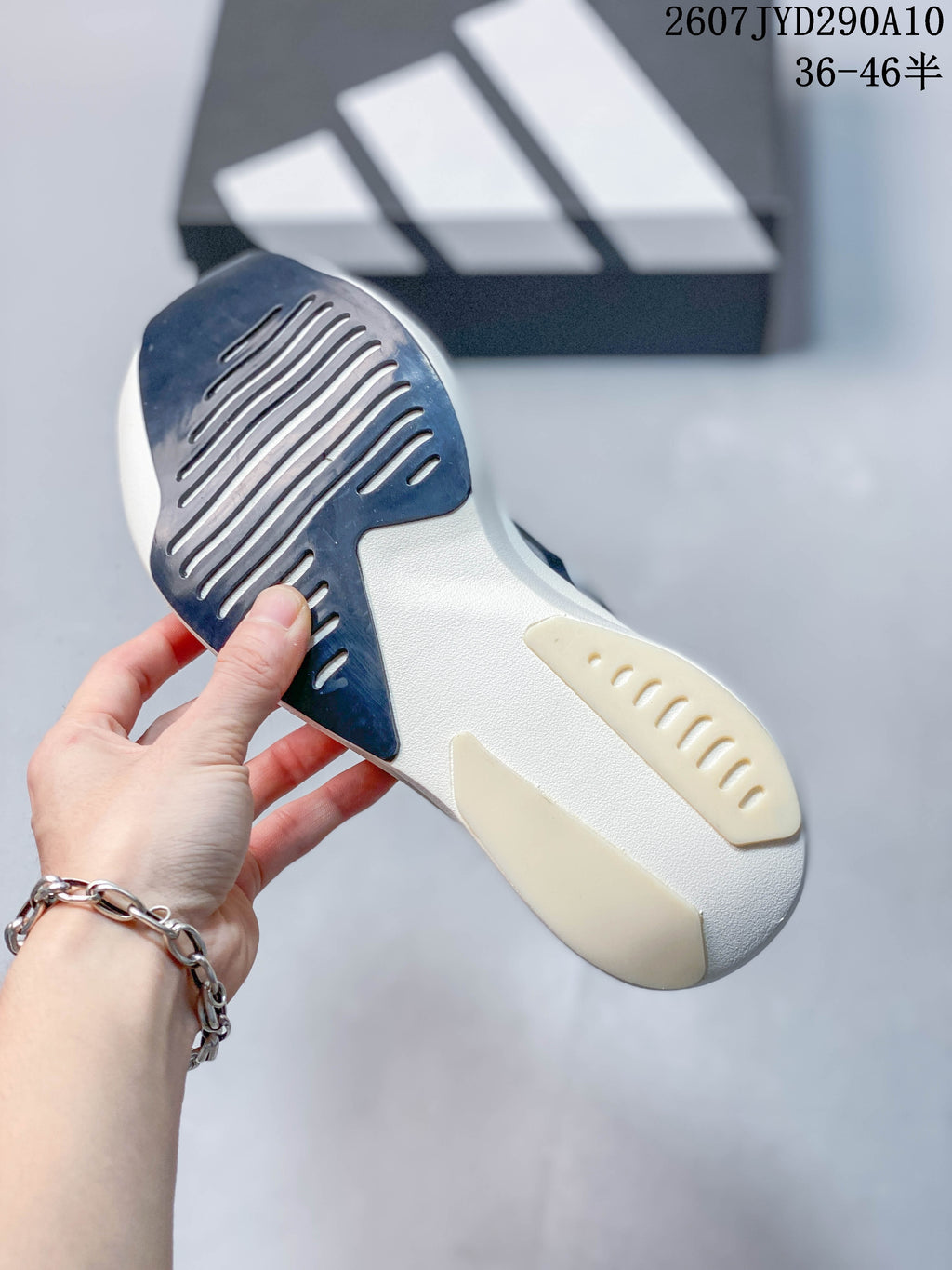 Underside view of the sneaker showing the white and dark navy outsole pattern.