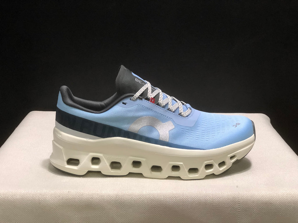 Single side view of the Cloudmonster 1 sneaker showing the light blue upper, dark heel panel, and white sole.