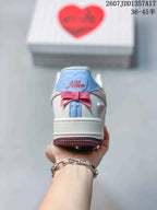 Rear view showing the blue heel panel, pink bow detail and heart-shaped side ornament.