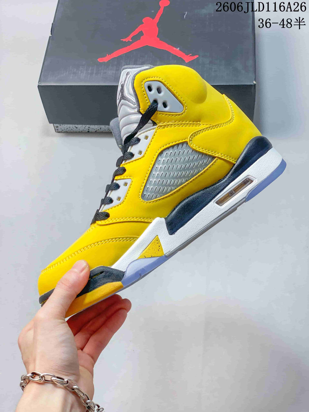 Side view highlighting the yellow upper, gray mesh panel, and visible heel cushioning