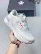 Angled side view of the white Descente sneaker showing the BOA closure, perforated panels, red accent, and sculpted sole.