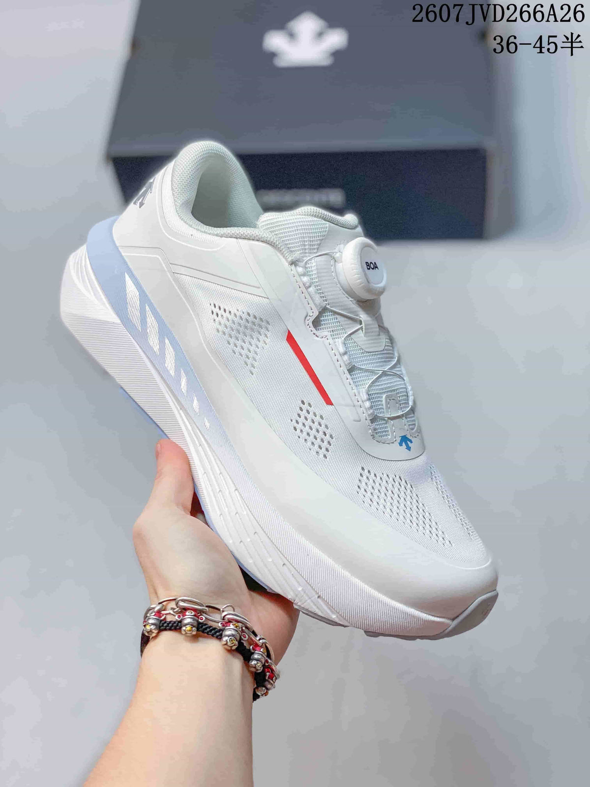 Angled side view of the white Descente sneaker showing the BOA closure, perforated panels, red accent, and sculpted sole.