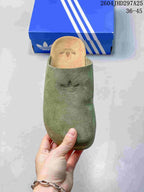 Top view of a green Adidas Adimule slide with tonal Trefoil branding and a cork-colored footbed.